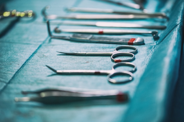 Photo ensemble d'instruments stériles disposés sur la table pour une opération sur un tissu bleu