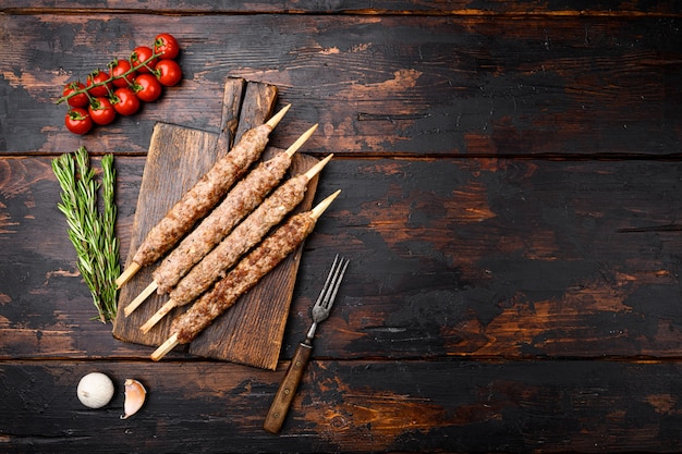 Ensemble de kebabs Tikka, shish et kofta, sur fond de table en bois foncé ancien, vue de dessus à plat, avec espace de copie pour le texte