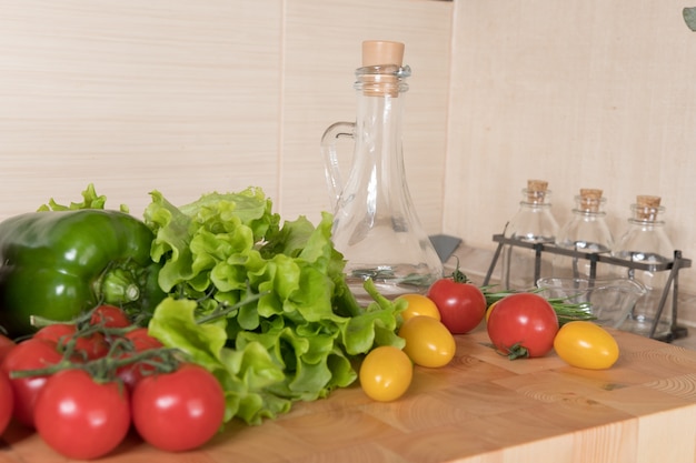 Ensemble de légumes de variété sur planche à découper dans la cuisine. Concepts d'alimentation saine. Ingrédients de la salade, tomates, poivrons, huile d'olive, épices