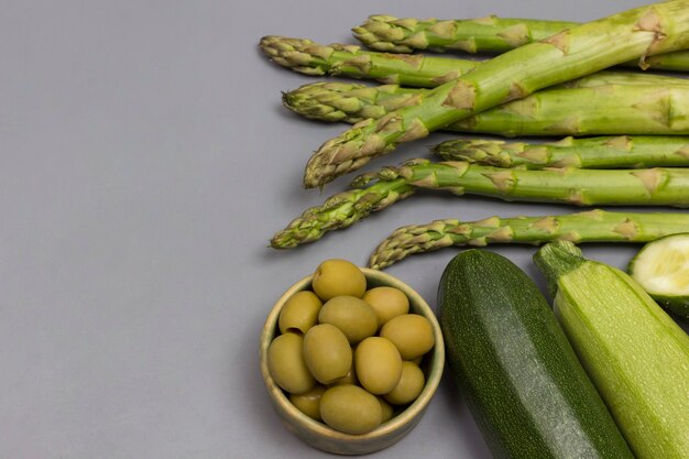 Ensemble de légumes verts sur fond gris.