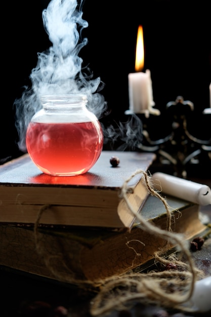 Ensemble de livre de sorcellerie, potion magique et bougies sur table