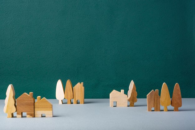 Ensemble de maison en bois et décoration d'arbres dans le village sur sol gris et fond vert