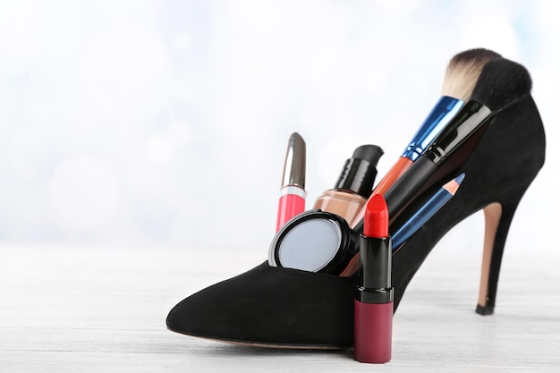 Ensemble de maquillage avec brosses à chaussures pour femme noire et cosmétiques sur fond blanc