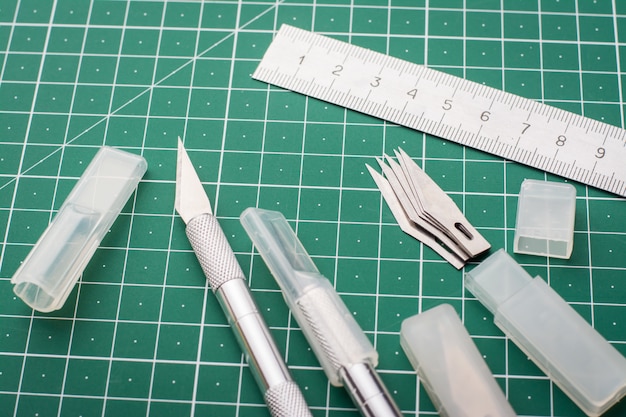 Ensemble de matériel professionnel pour la découpe de papier photo, plastique. Kit de scalpels, lames et règle sur tapis de découpe avant