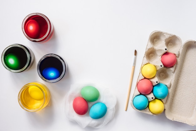 Photo ensemble de mort d'oeufs de bricolage, plateau d'oeufs de pâques colorés sur fond blanc. mise à plat.