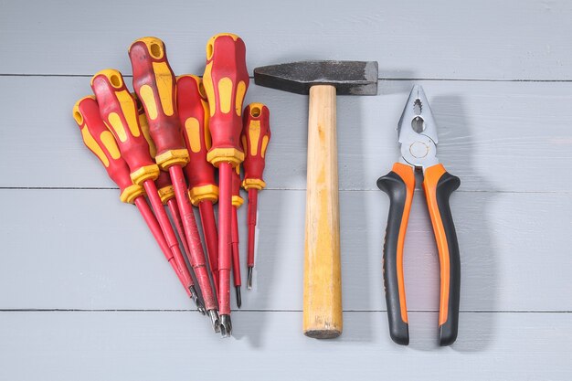 Un ensemble de nombreux outils rouges différents pour le travail comprend un tournevis à percussion sur gris. Vue de dessus