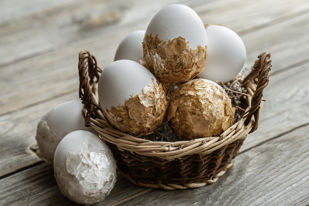 Ensemble d'oeufs de Pâques festifs dans un panier en osier sur une table floue. Concept de vacances de Pâques.