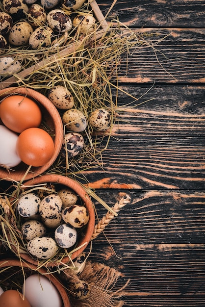 Un ensemble d'oeufs de poulet et de caille Sur un fond en bois Vue de dessus Espace de copie