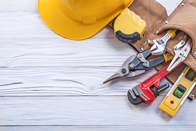 Ensemble d'outillage de construction en casque de ceinture à outils sur planche de bois