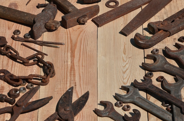 Un ensemble d&#39;outils anciens et rouillés repose sur une table en bois dans l&#39;atelier