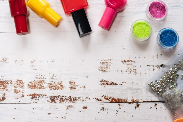 Ensemble d'outils de manucure et vernis à ongles sur un fond en bois blanc.