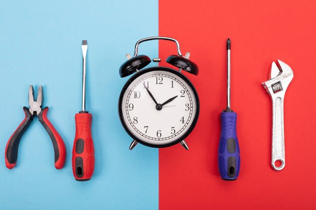 Photo ensemble d'outils avec réveil sur bleu-rouge