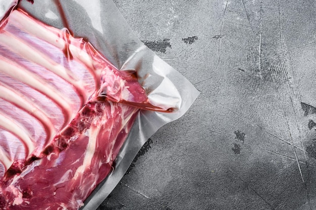 Ensemble de pack de côtes d'agneau, sur fond de table en pierre grise, vue de dessus à plat, avec espace de copie pour le texte