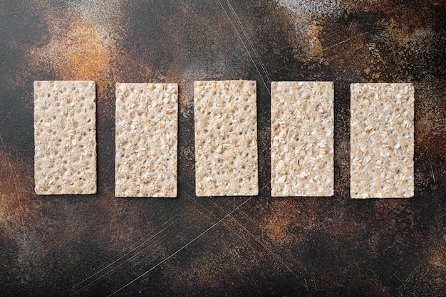 Ensemble de pain croustillant à grains entiers, sur une vieille table rustique sombre, vue de dessus à plat