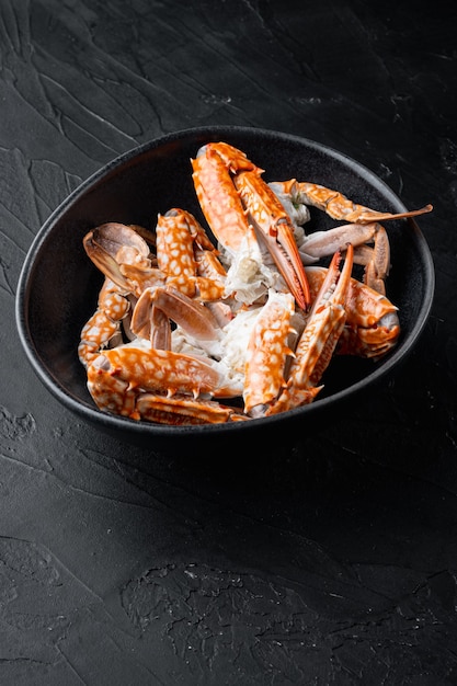 Ensemble de pièces de viande bouillie de crabe bleu thaïlandais, sur fond noir