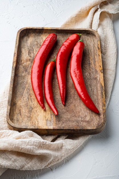 Ensemble de piment rouge cru, sur fond texturé blanc