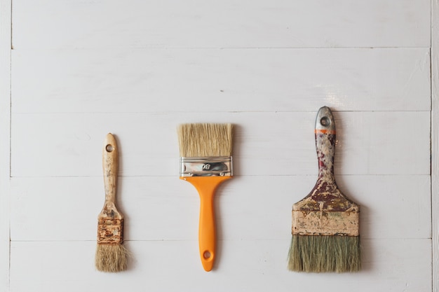 Ensemble de pinceaux avec de la peinture sur la teinture en bois blanc