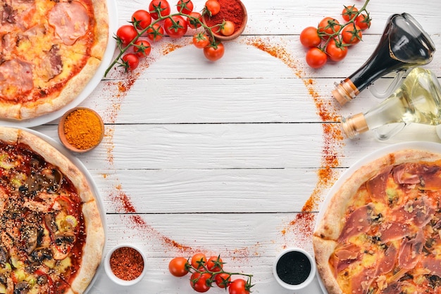 Un ensemble de pizzas italiennes Cuisine italienne Sur un fond en bois blanc Espace de copie gratuit Vue de dessus
