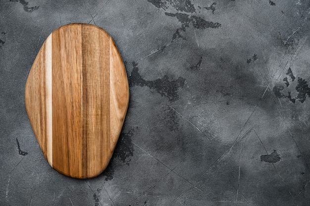 Ensemble de planche à découper en bois, sur fond de table en pierre grise, vue de dessus à plat, avec espace de copie pour le texte ou votre produit