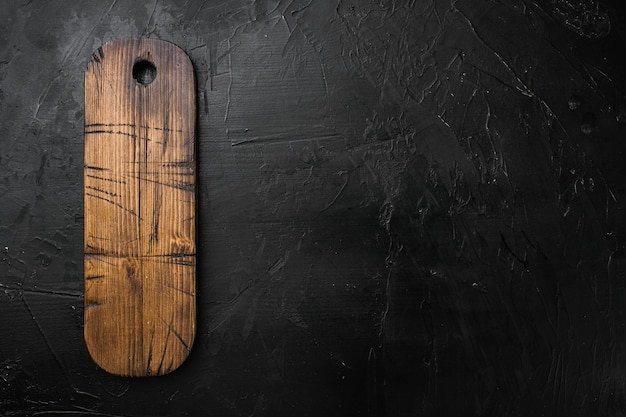 Ensemble de planche à découper en bois vide, vue de dessus à plat, avec espace de copie pour le texte ou votre produit, sur fond de table en pierre noire noire