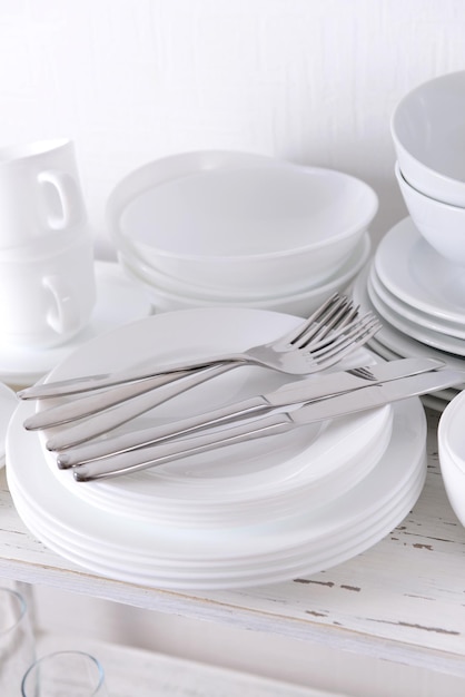 Ensemble de plats blancs sur table sur fond clair