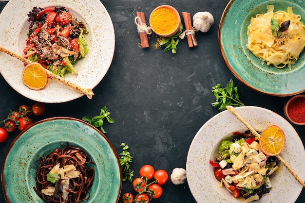 Un ensemble de plats Pâtes au parmesan et salade de légumes et fromage bleu Vue de dessus Espace libre pour votre texte Sur un fond en bois