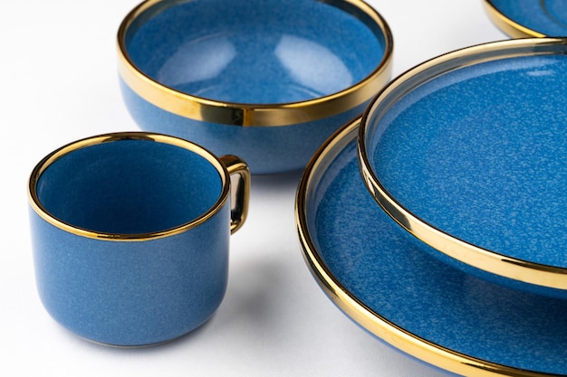 Un ensemble de plats et de tasse en céramique bleus sur un fond blanc