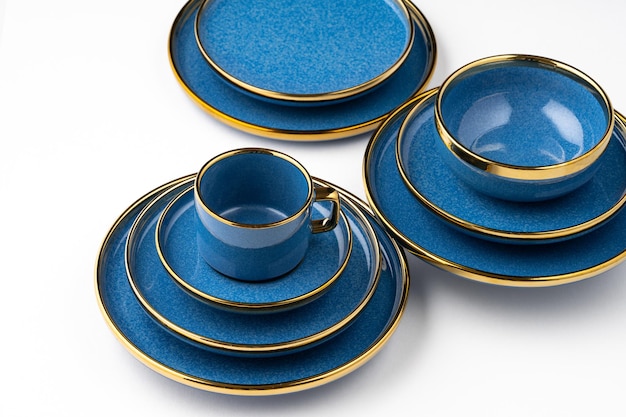 Un ensemble de plats et de tasse en céramique bleus sur un fond blanc