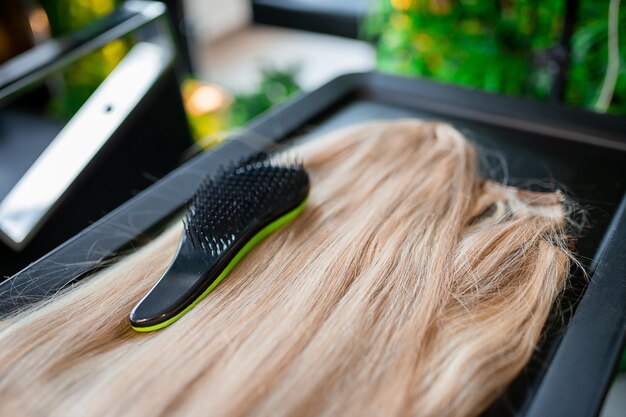 Un ensemble de plusieurs outils d'extension de cheveux pour une femme blonde dans un salon de beauté