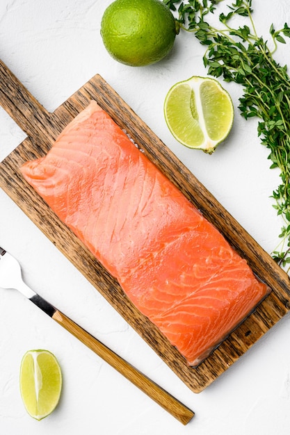 Ensemble de poisson de filet de saumon, aux herbes, sur fond de table en pierre blanche, vue de dessus à plat