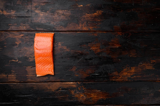 Ensemble de poisson de filet de saumon, sur le vieux fond de table en bois foncé, vue de dessus à plat, avec espace de copie pour le texte