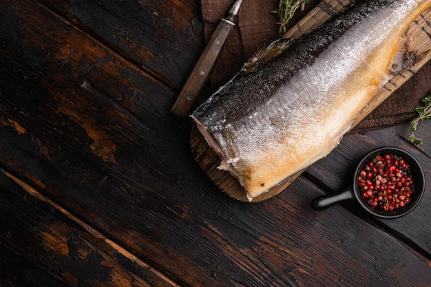 Ensemble de poisson fumé chaud entier, sur fond de table en bois foncé ancien, vue de dessus à plat, avec espace de copie pour le texte