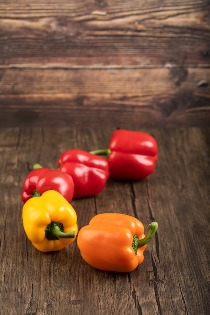 Ensemble de poivrons doux colorés sur une surface en bois