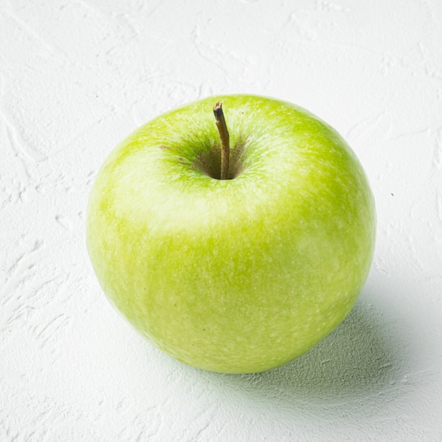 Ensemble de pommes Granny Smith, sur fond de table en pierre blanche, format carré