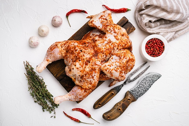 Ensemble de poulet au tabac cru, sur fond de table en pierre blanche, vue de dessus à plat