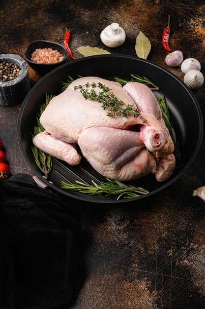 Ensemble de poulet cru, sur un vieux fond de table rustique sombre, avec un espace de copie pour le texte