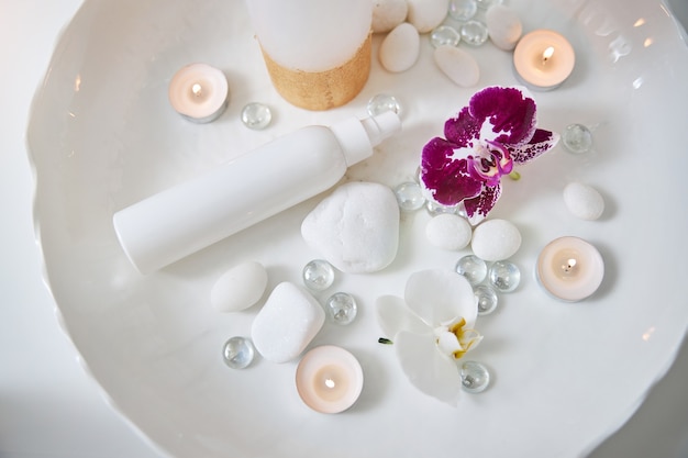 Ensemble pour la procédure de spa avec des orchidées et une bouteille de lotion