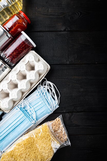 Ensemble de produits alimentaires. Ravitaillement. Concept de don, de coronavirus et de quarantaine, vue de dessus avec espace de copie, sur table en bois noir