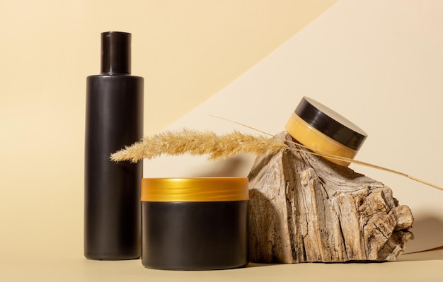 Un ensemble de produits cosmétiques à côté d'une bûche et d'ombres dures sur fond beige Cosmétiques bio naturels