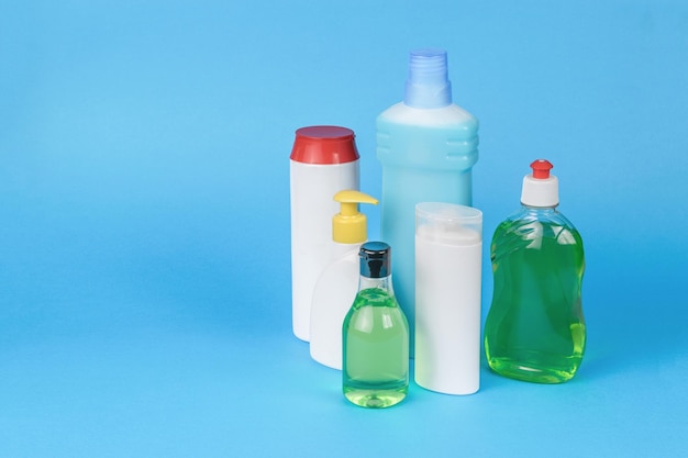 Un ensemble de produits de nettoyage dans des bouteilles en plastique sur fond bleu