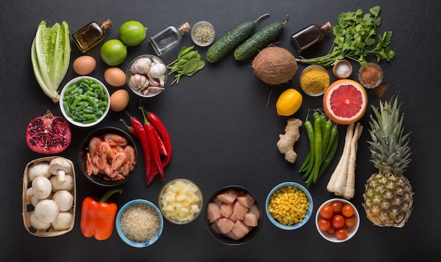 Ensemble de produits pour la préparation de plats de cuisine thaïlandais sur fond noir, vue de dessus