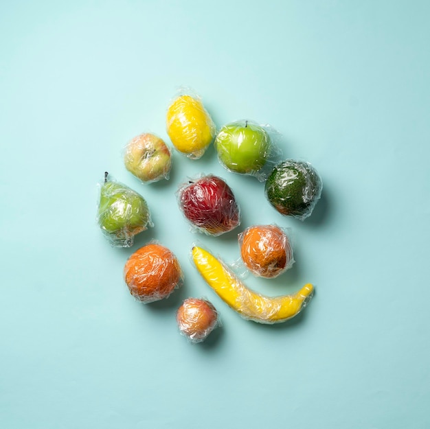 Un ensemble de quelques fruits frais dans une pellicule plastique transparente