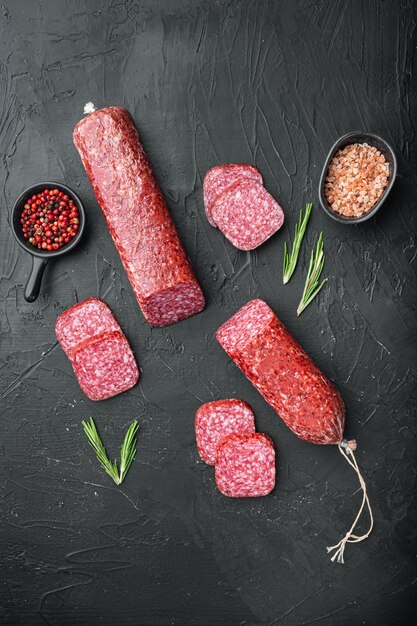 Ensemble de romarin frais et d'épices de saucisse, sur fond de table en pierre noire noire, vue de dessus à plat