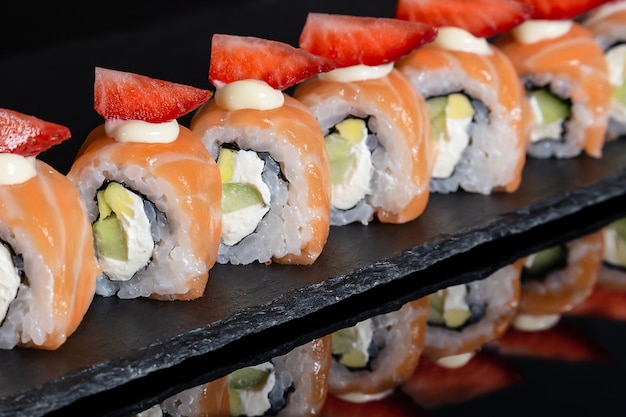 Ensemble de rouleaux de sushi sur fond de bureau noir