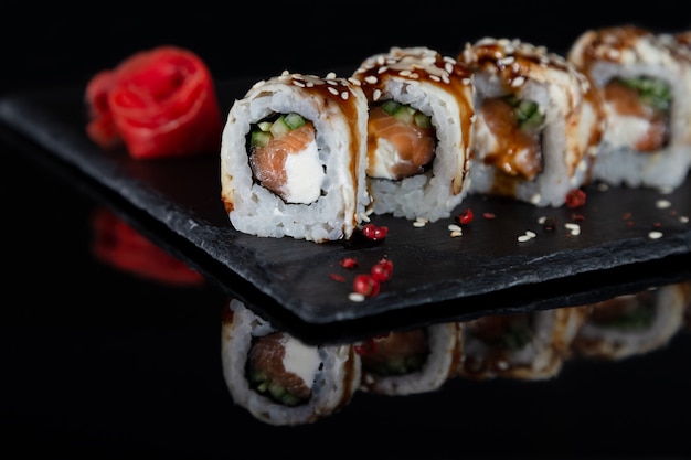 Ensemble de rouleaux de sushi sur fond de bureau de pierre noire