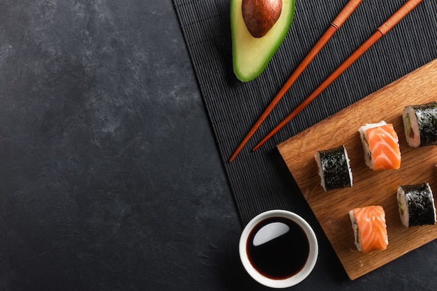 Ensemble de rouleaux de sushi et maki avec avocat tranché sur table en pierre. Vue de dessus.