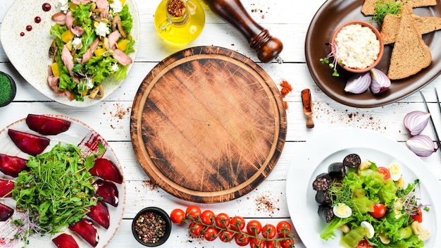 Ensemble de salades et plats sur fond de bois blanc Vue de dessus espace libre pour votre texte Style rustique