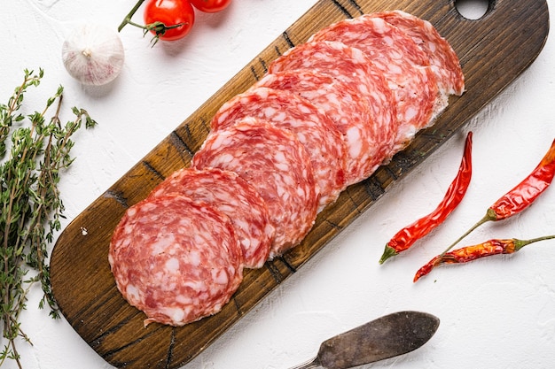 Ensemble de salami de tranches de saucisse fumée, sur fond de table en pierre blanche, vue de dessus à plat