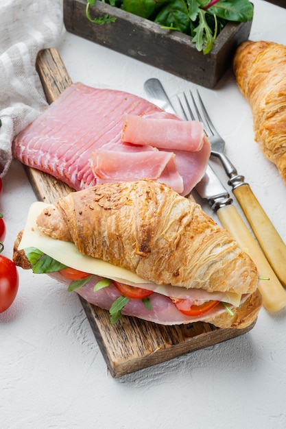 Ensemble de sandwichs croissant BLT classique, avec des herbes et des ingrédients, sur fond de pierre blanche