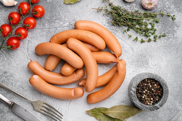 Ensemble de saucisses barbecue crues, sur fond de table en pierre grise, vue de dessus à plat